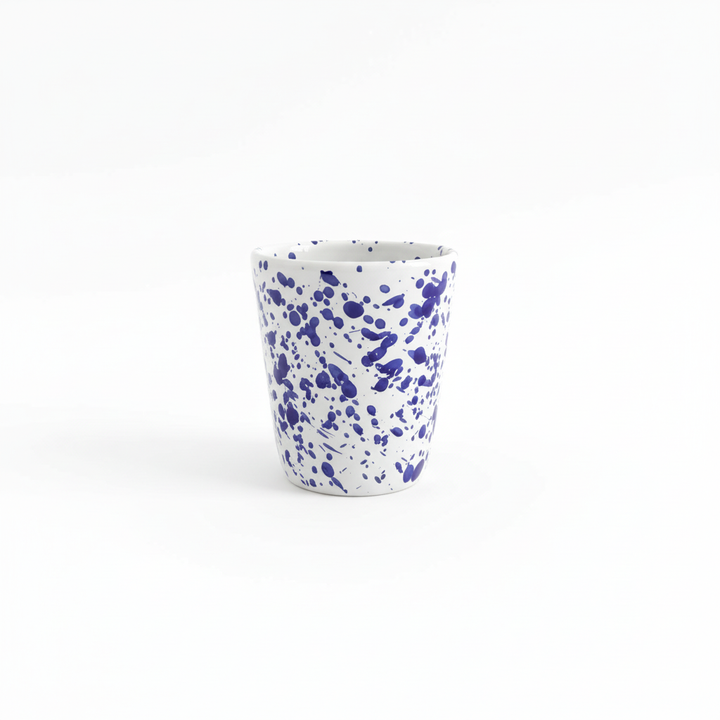 Bicchiere ceramica blu schizzato sfondo bianco